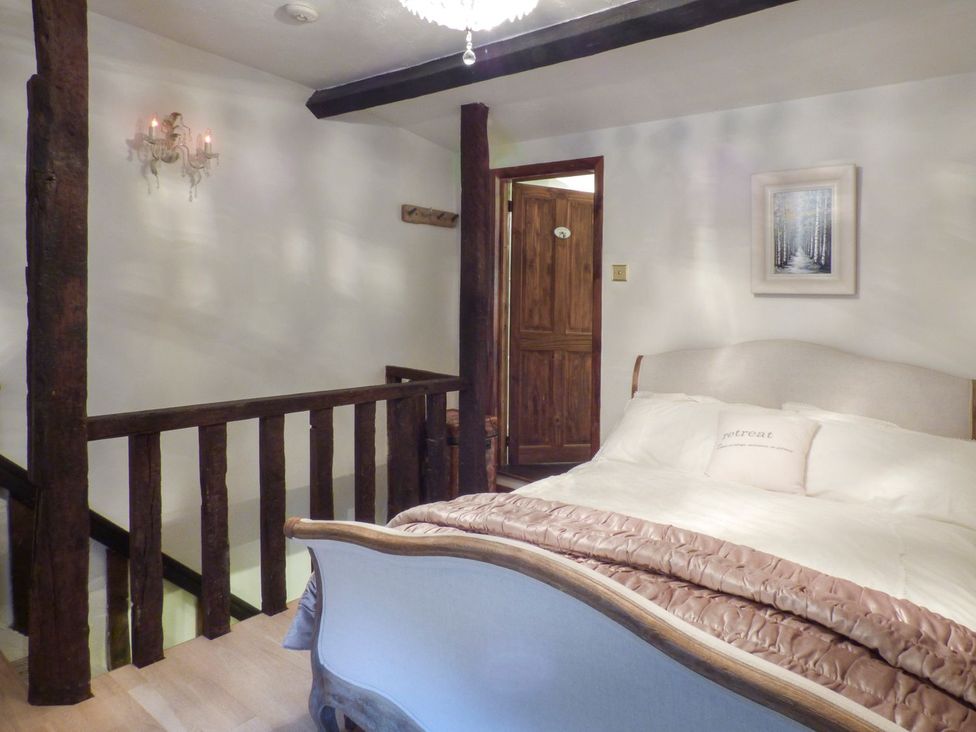 A bedroom with a bed and wooden features at Squirrel Cottage in Betws-Y-Coed