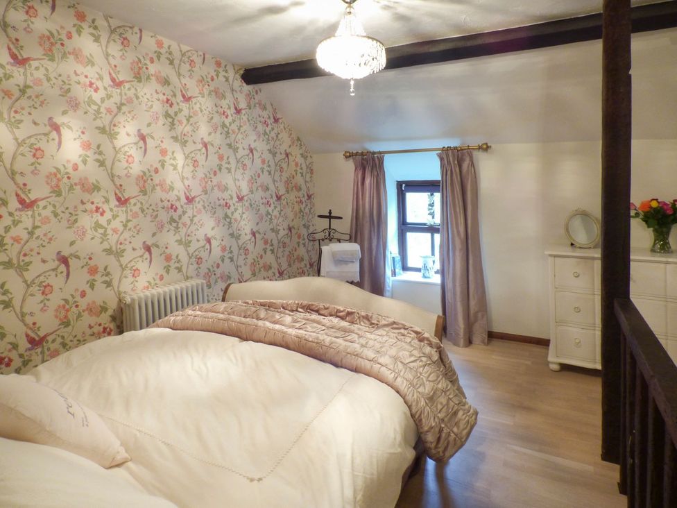 A bedroom with a bed and window at Squirrel Cottage in Betws-Y-Coed