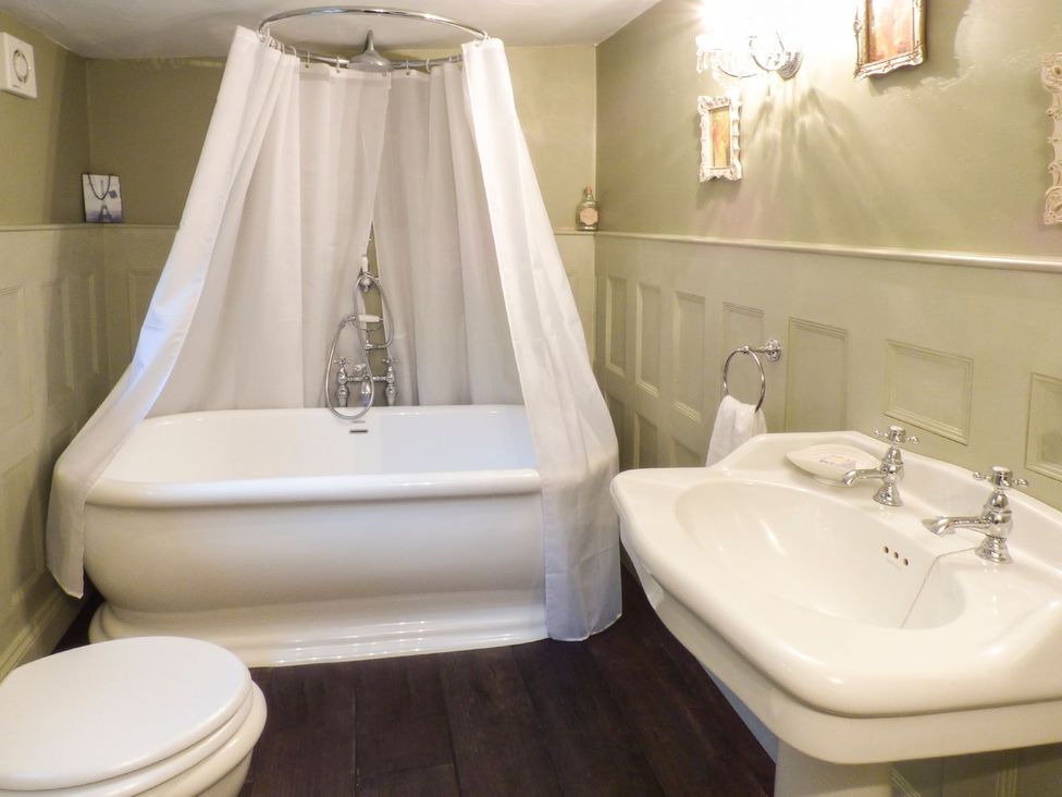 A bathroom featuring a bathtub, toilet, and sink at Squirrel Cottage in Betws-Y-Coed