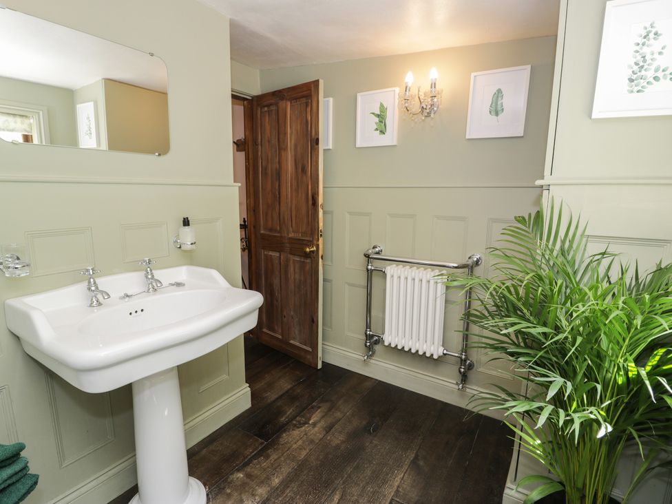 A bathroom with a sink and a mirror at Squirrel Cottage in Betws-Y-Coed