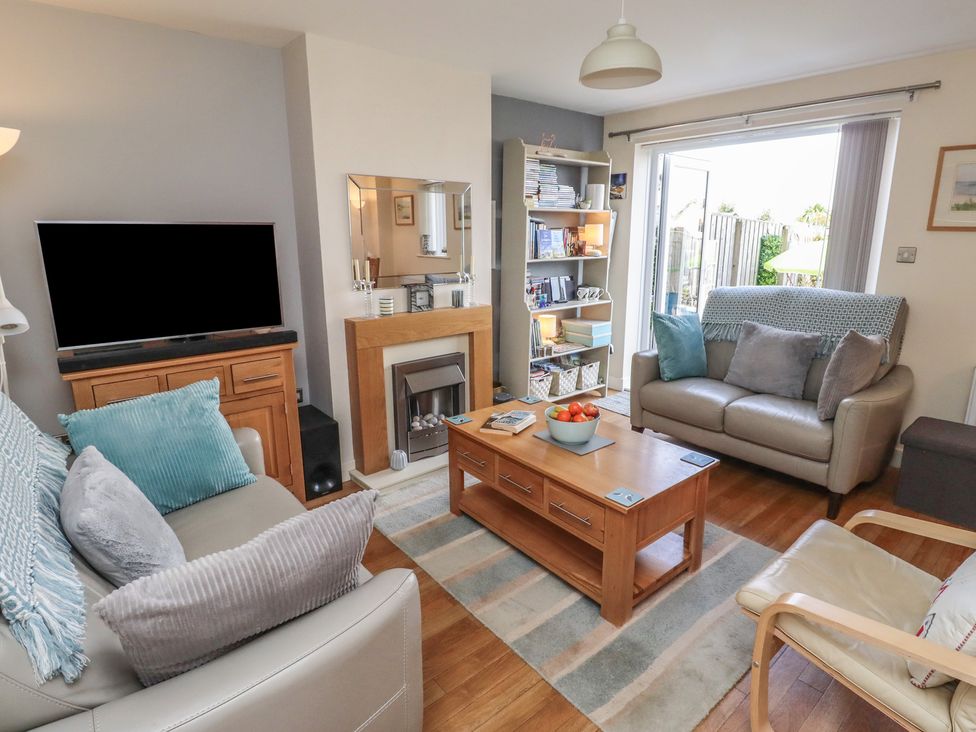 A living room with a television and sofa at Tidal Watch in Seahouses