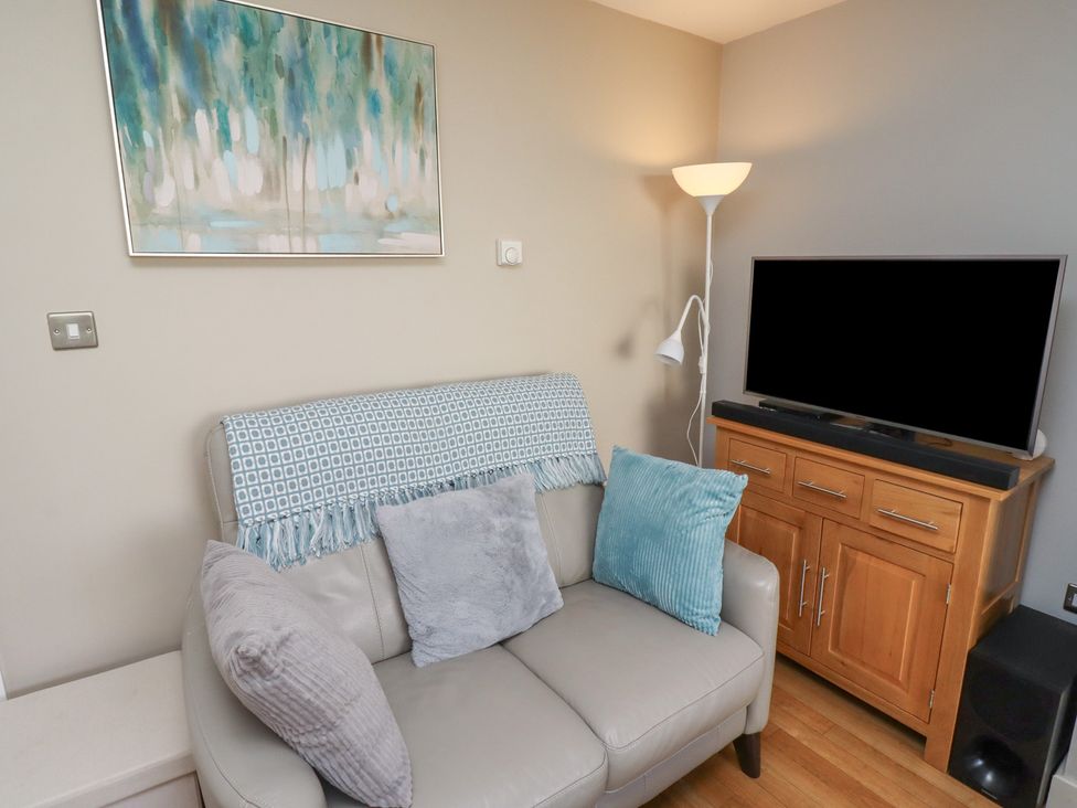A living room with a sofa and television at Tidal Watch in Seahouses