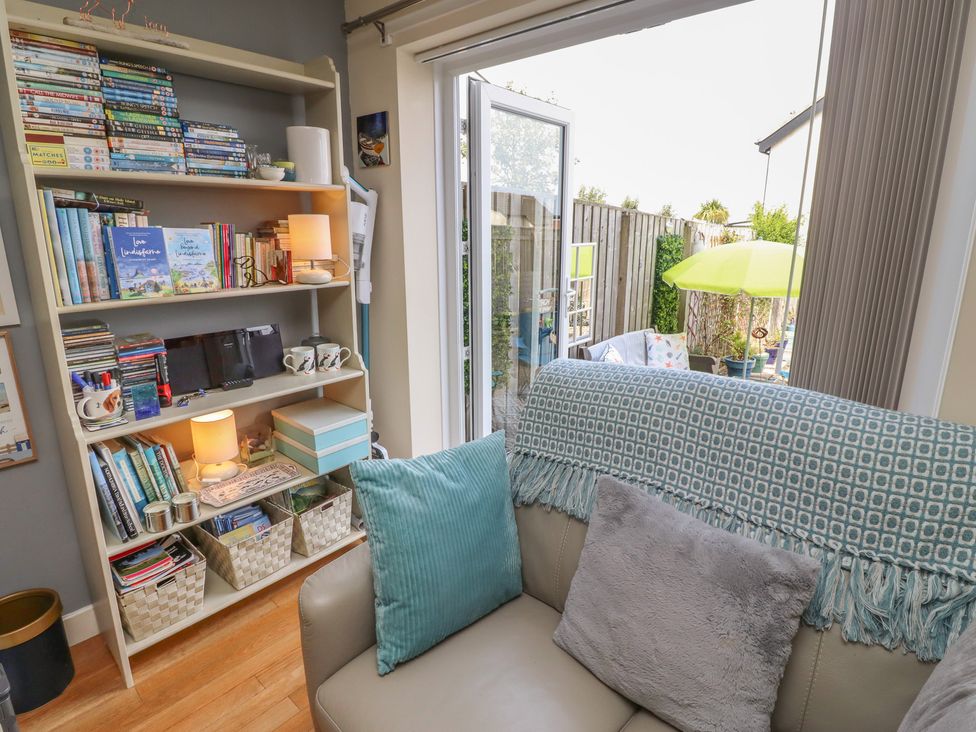 A snug with bookshelves and a sofa at Tidal Watch in Seahouses
