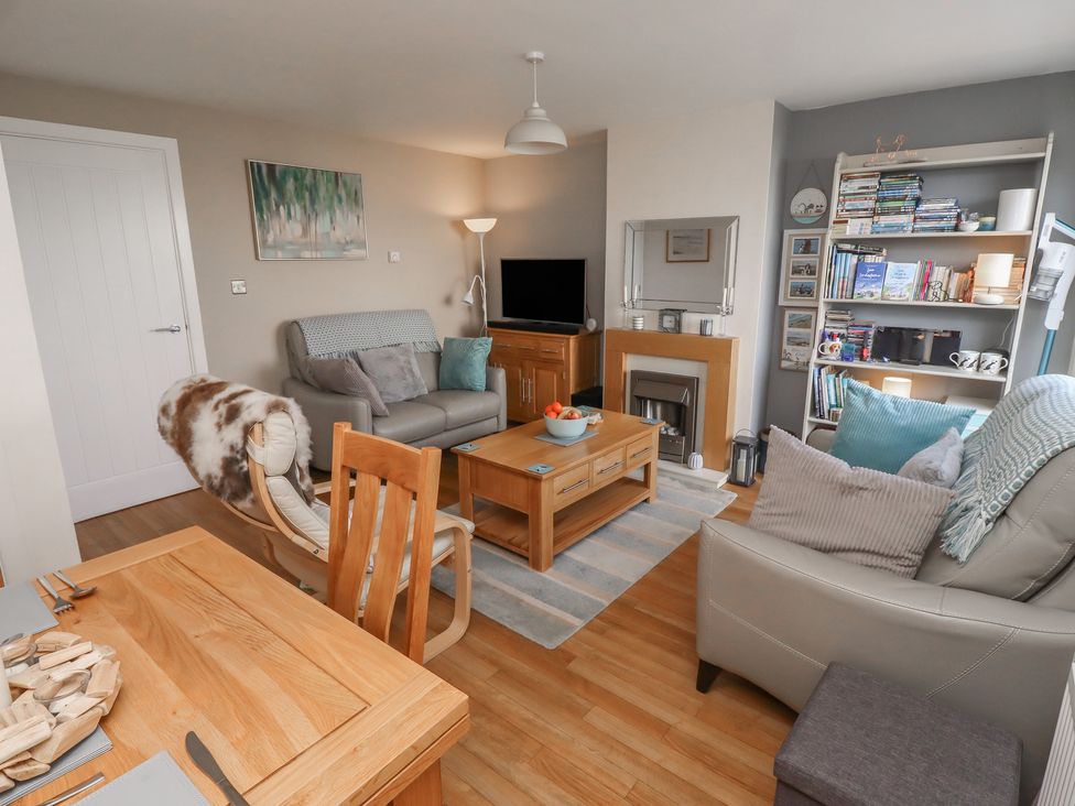 A living room with sofa and television at Tidal Watch in Seahouses