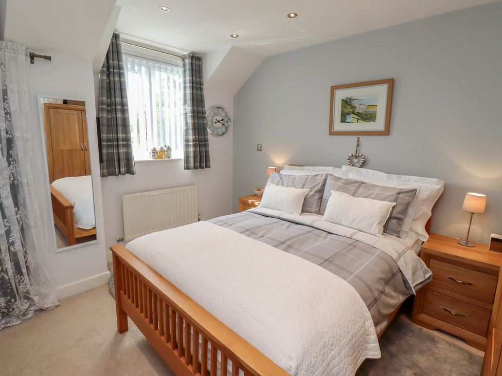 A bedroom with a bed and nightstands at Tidal Watch in Seahouses