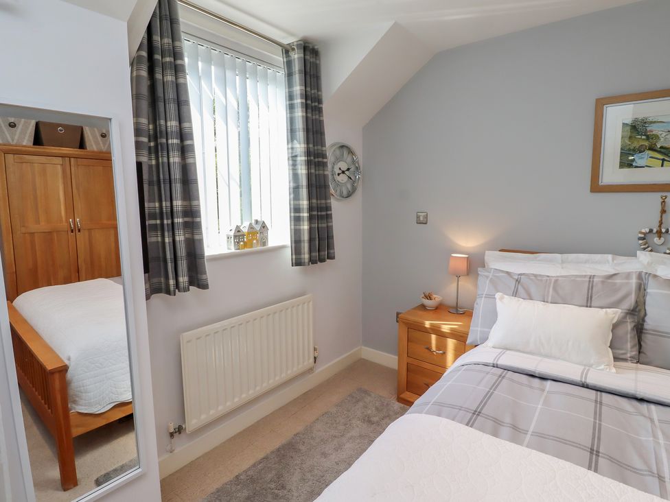 A bedroom with a bed and nightstand at Tidal Watch in Seahouses