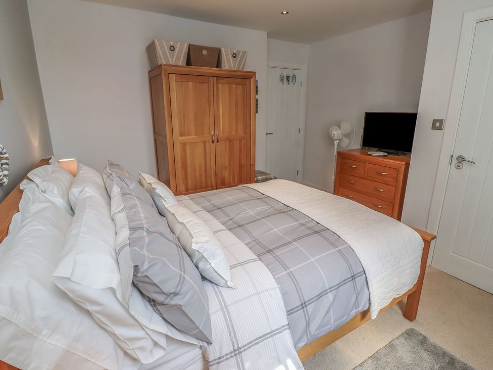 A bedroom with a bed and wardrobe at Tidal Watch in Seahouses