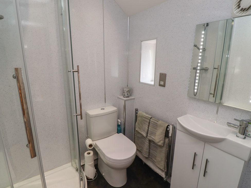 A bathroom with shower, toilet, and sink at Tidal Watch, Seahouses