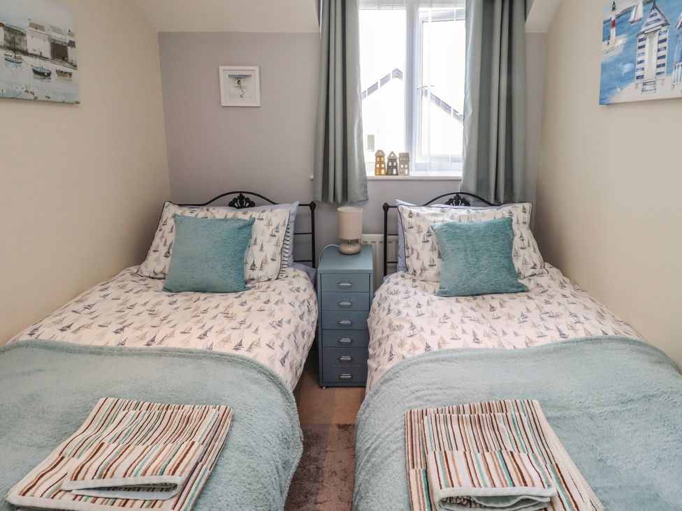A bedroom with two single beds and a chest of drawers at Tidal Watch in Seahouses