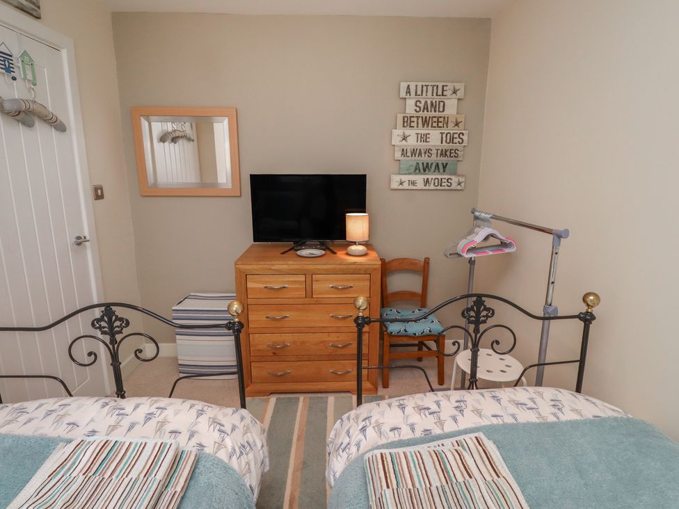 A bedroom with beds and a television at Tidal Watch in Seahouses