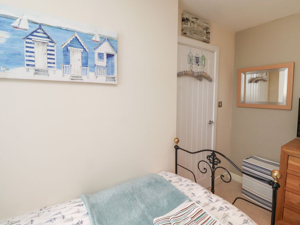 A bedroom with a bed and wall art at Tidal Watch in Seahouses