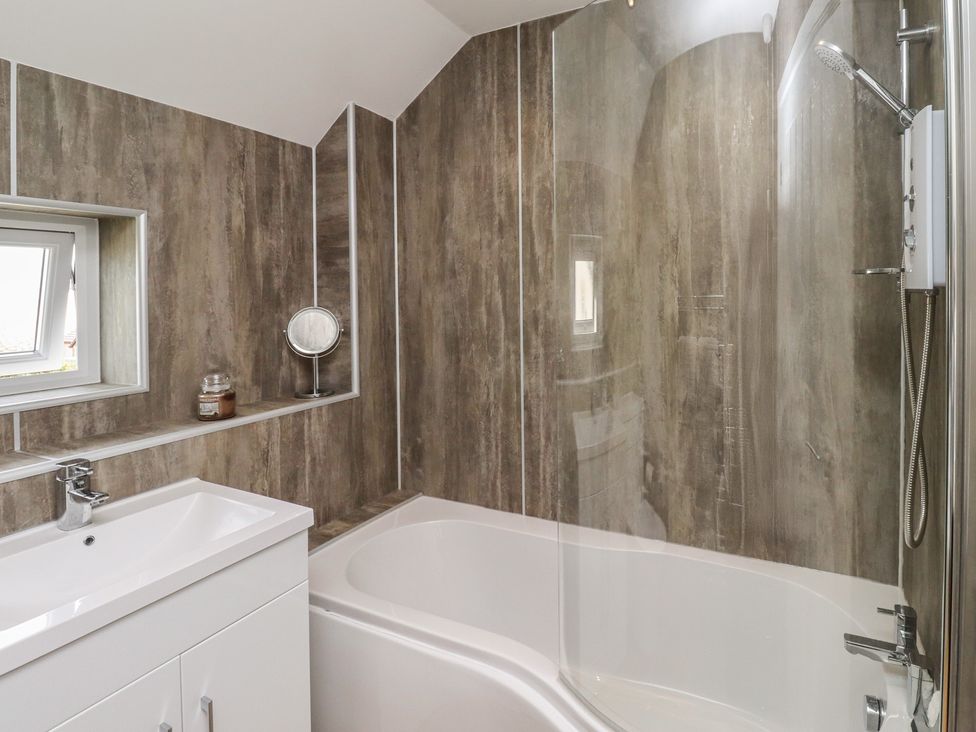 A bathroom with a bathtub and sink at Tidal Watch in Seahouses