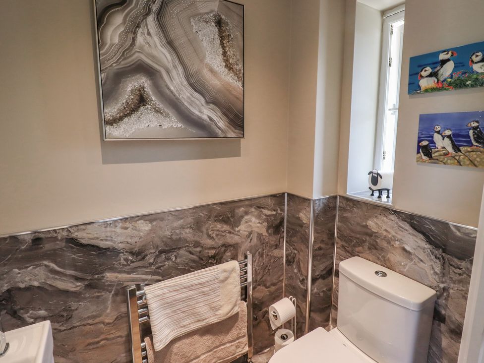 A bathroom featuring a toilet, towel rack, and wall art at Tidal Watch in Seahouses