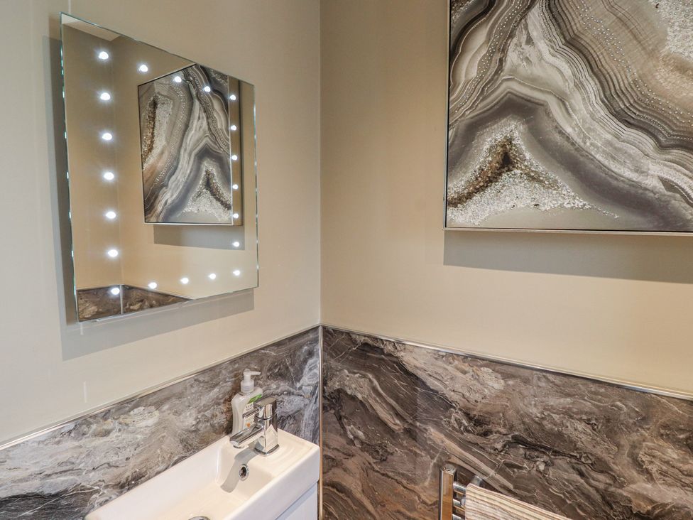 A bathroom with a mirror and sink at Tidal Watch in Seahouses