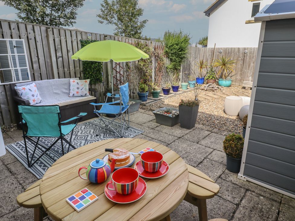 A garden with seating and a dining table at Tidal Watch Seahouses