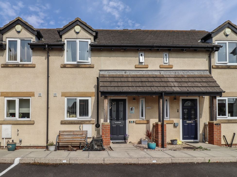 A house facade featuring benches and plants at Tidal Watch in Seahouses