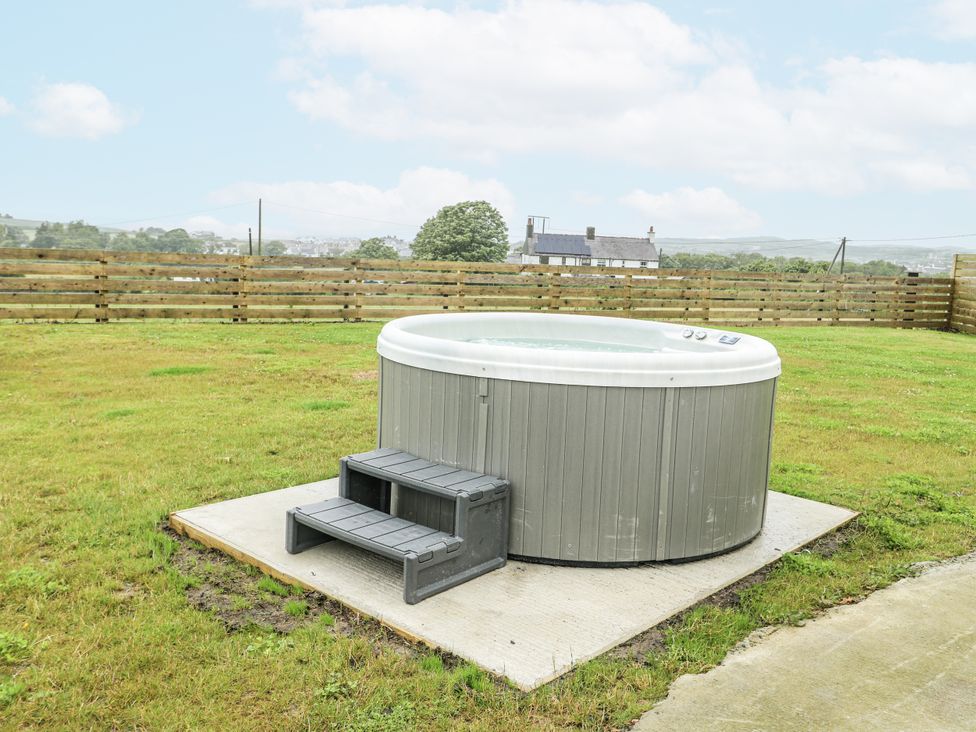 A hot tub with steps on a patio in outdoor space at The Old Cornmill in Cemaes Bay