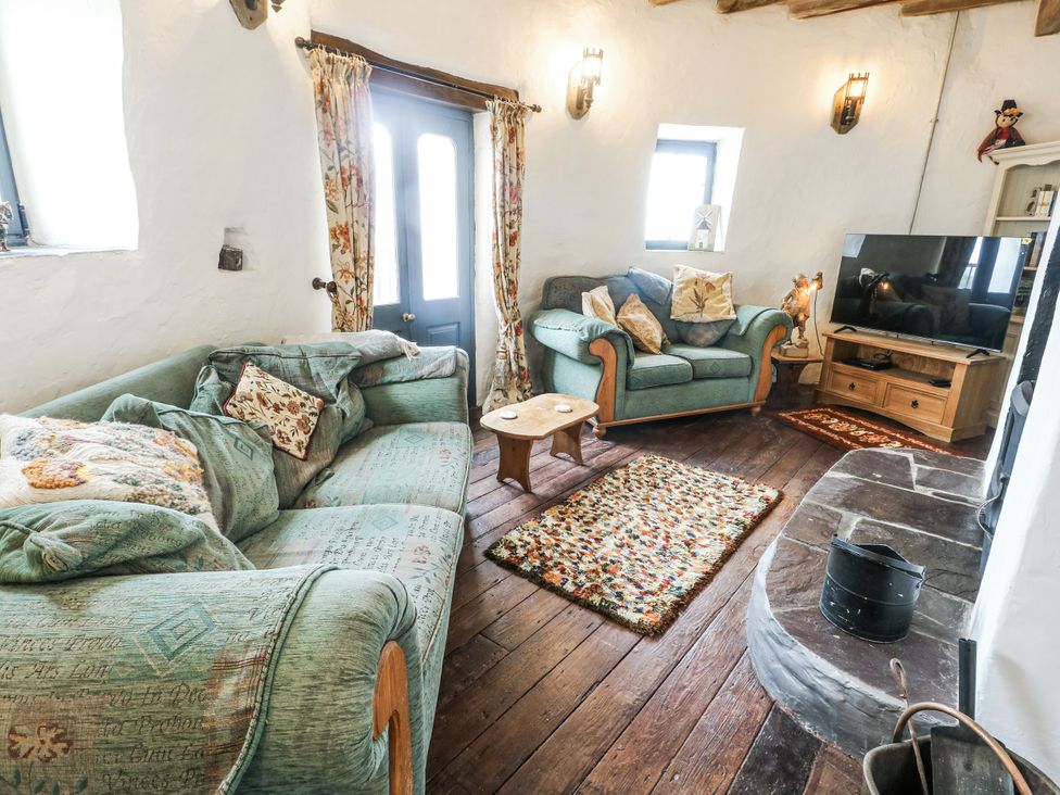 A living room with sofas and a television at The Old Cornmill in Cemaes Bay