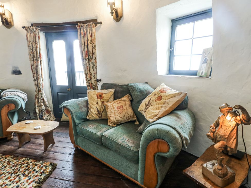 A living room with a sofa and coffee table at The Old Cornmill in Cemaes Bay