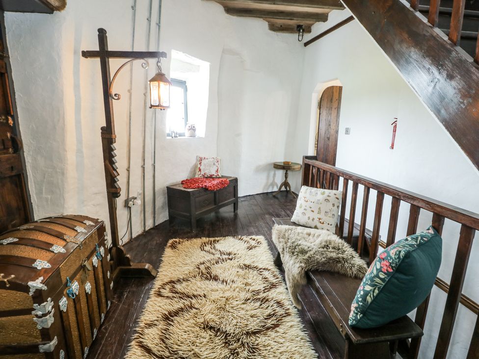 A snug room with a chest and seating at The Old Cornmill in Cemaes Bay