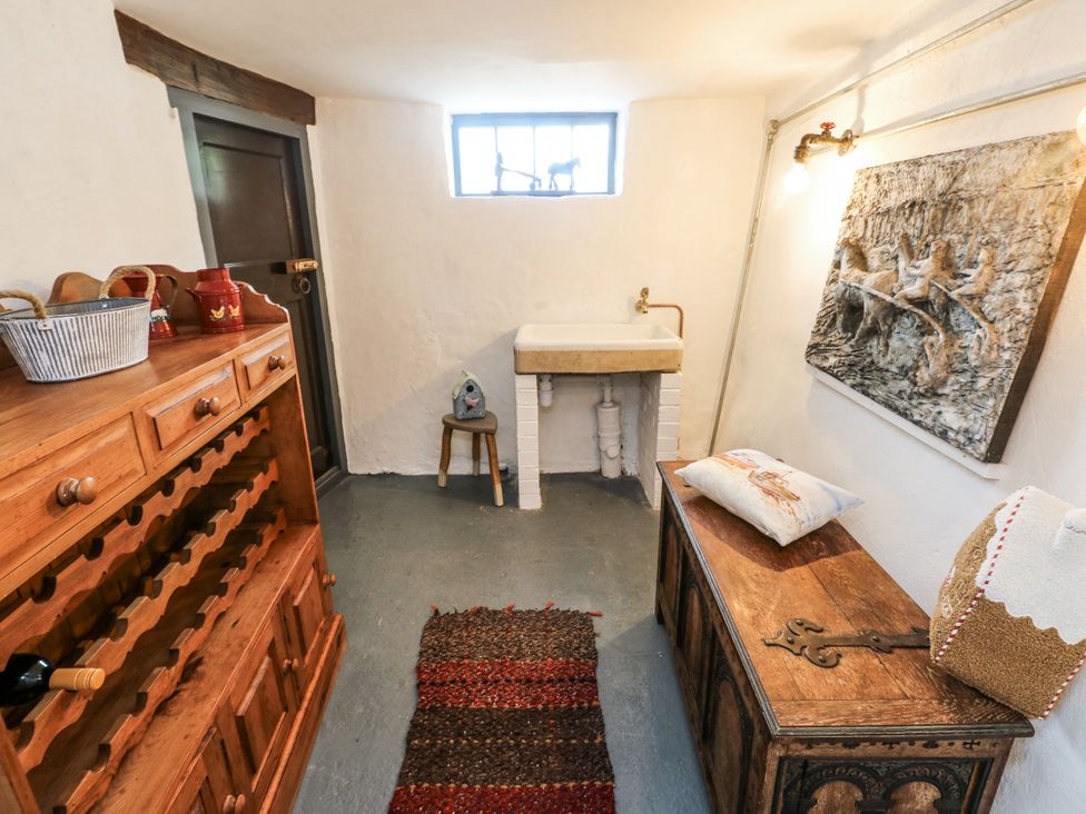 A utility room with a sink and storage unit at The Old Cornmill in Cemaes Bay