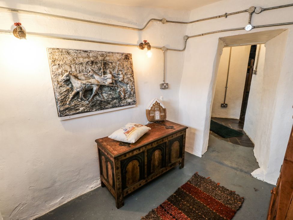 A hallway with a chest and wall art at The Old Cornmill in Cemaes Bay