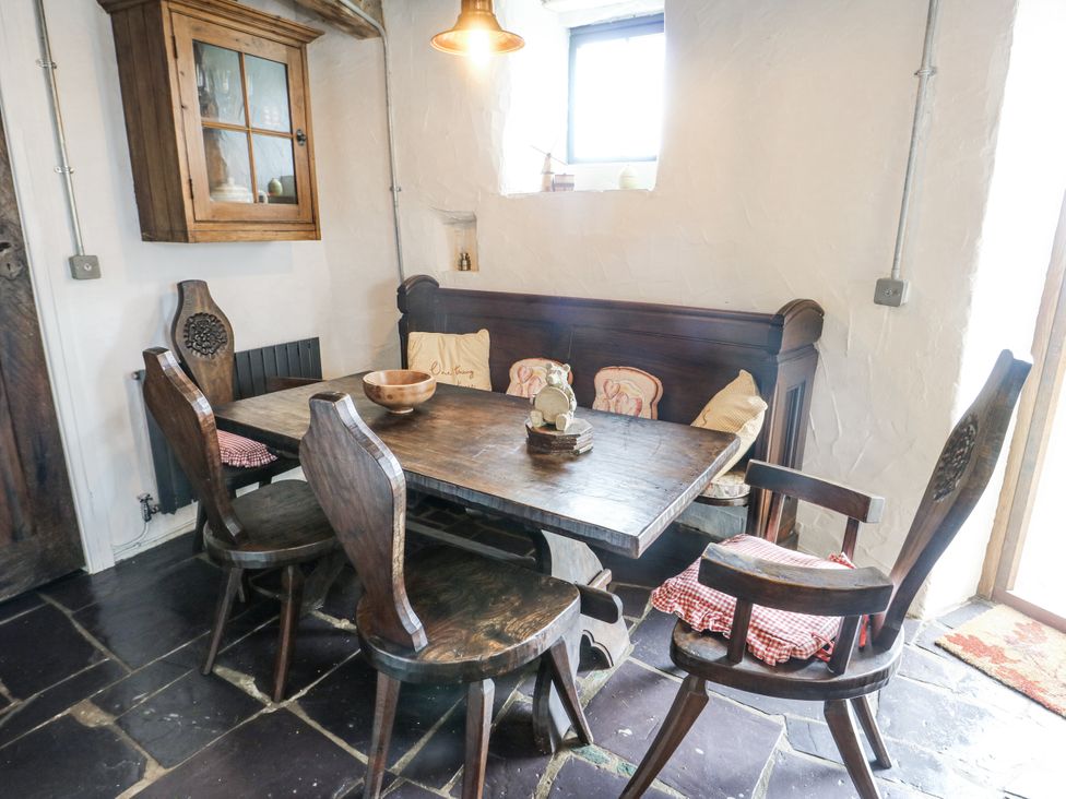 A dining room with a wooden table and chairs at The Old Cornmill Cemaes Bay