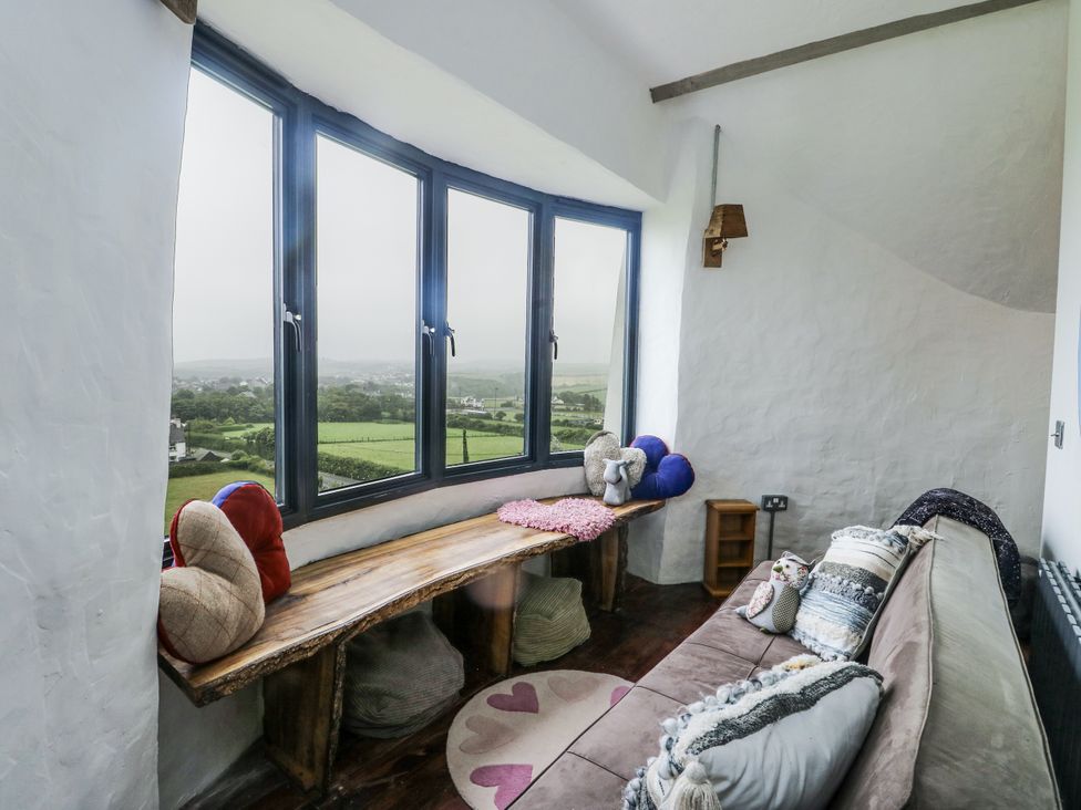 A sitting room with a view and a wooden bench at The Old Cornmill in Cemaes Bay