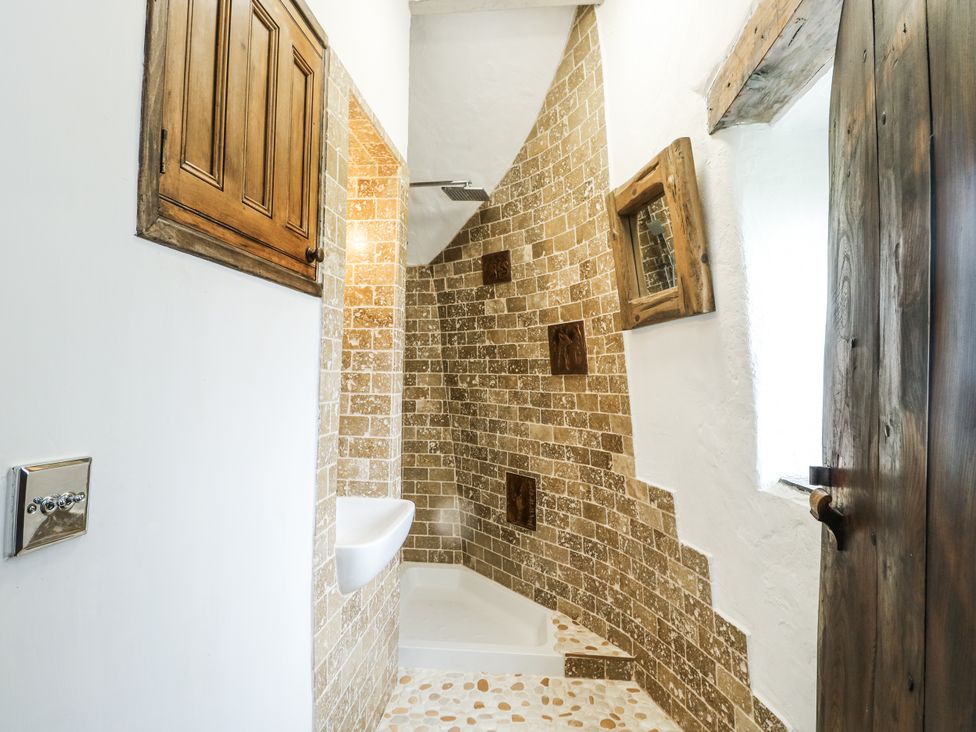 A bathroom with a shower, toilet, and sink at The Old Cornmill in Cemaes Bay