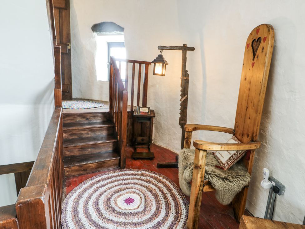 A landing area with a wooden chair and small table at The Old Cornmill in Cemaes Bay