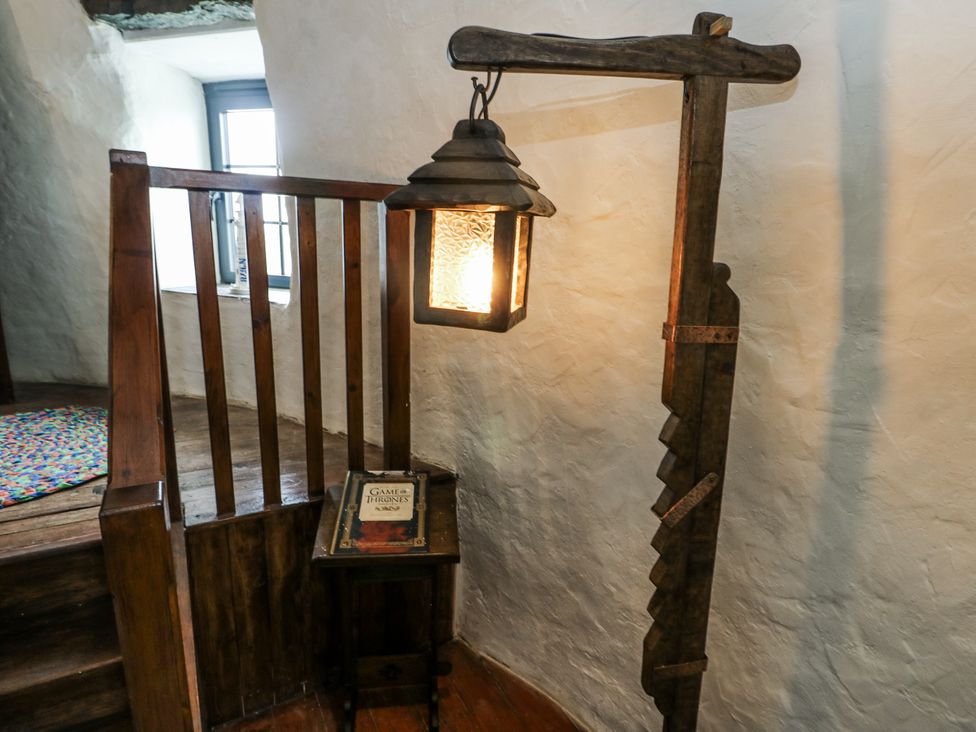 A staircase with a lamp and a book at The Old Cornmill in Cemaes Bay