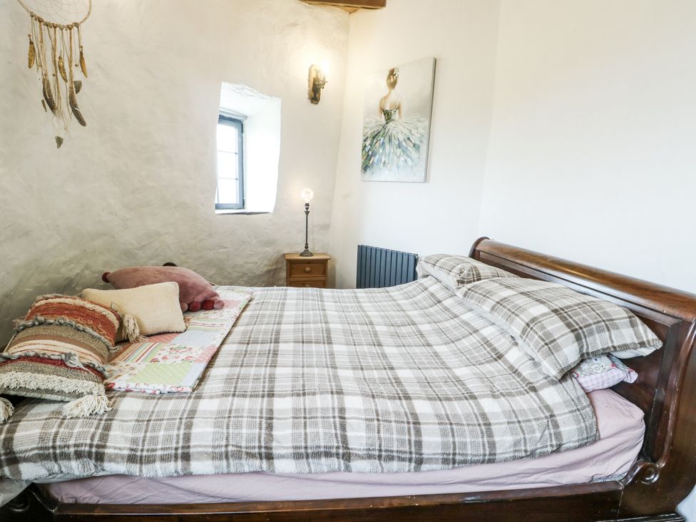 A bedroom with a bed and nightstand at The Old Cornmill in Cemaes Bay