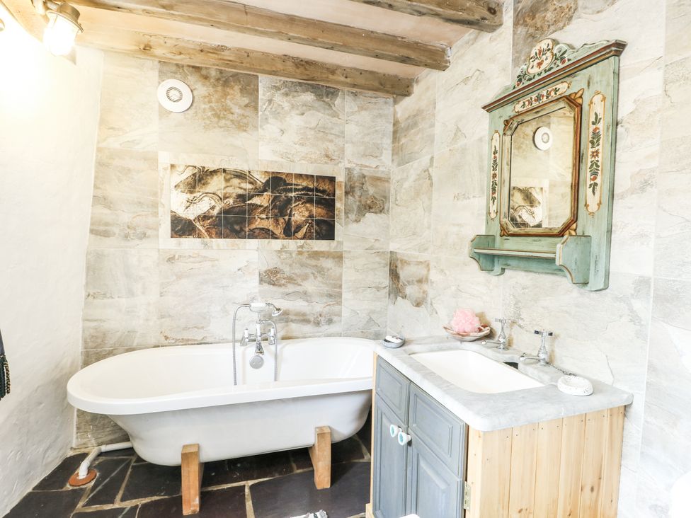 A bathroom with a bathtub and sink at The Old Cornmill in Cemaes Bay