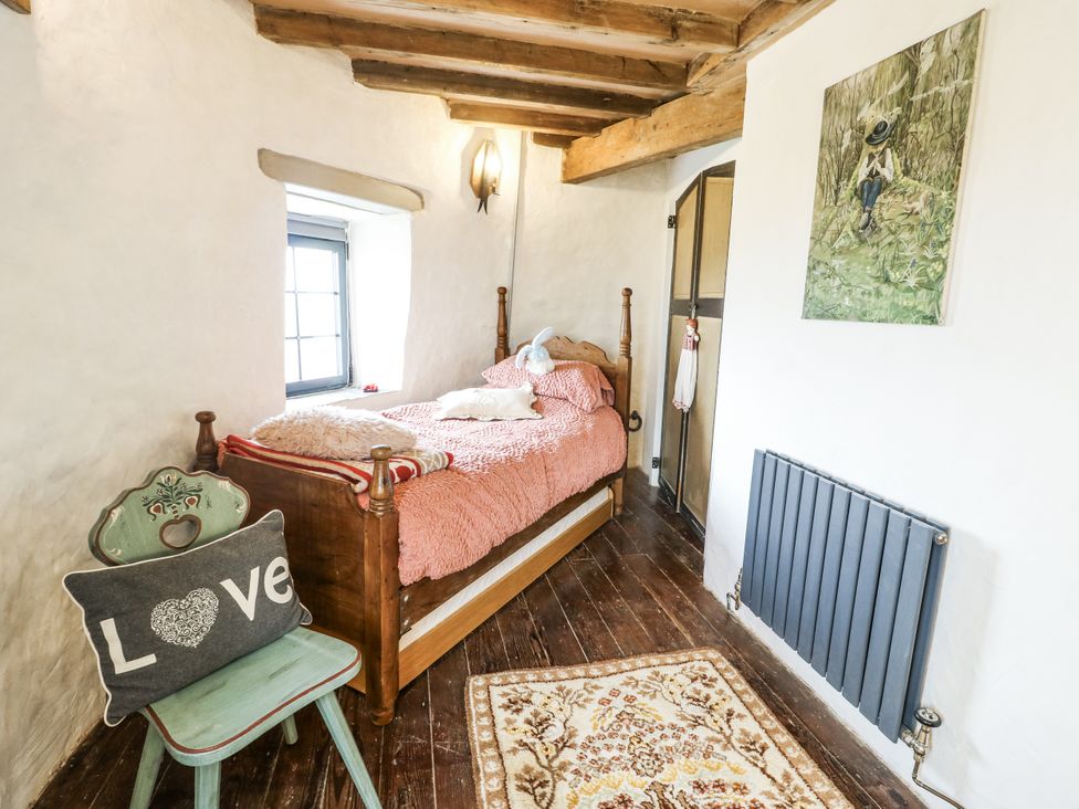 A bedroom with a bed and artwork at The Old Cornmill in Cemaes Bay