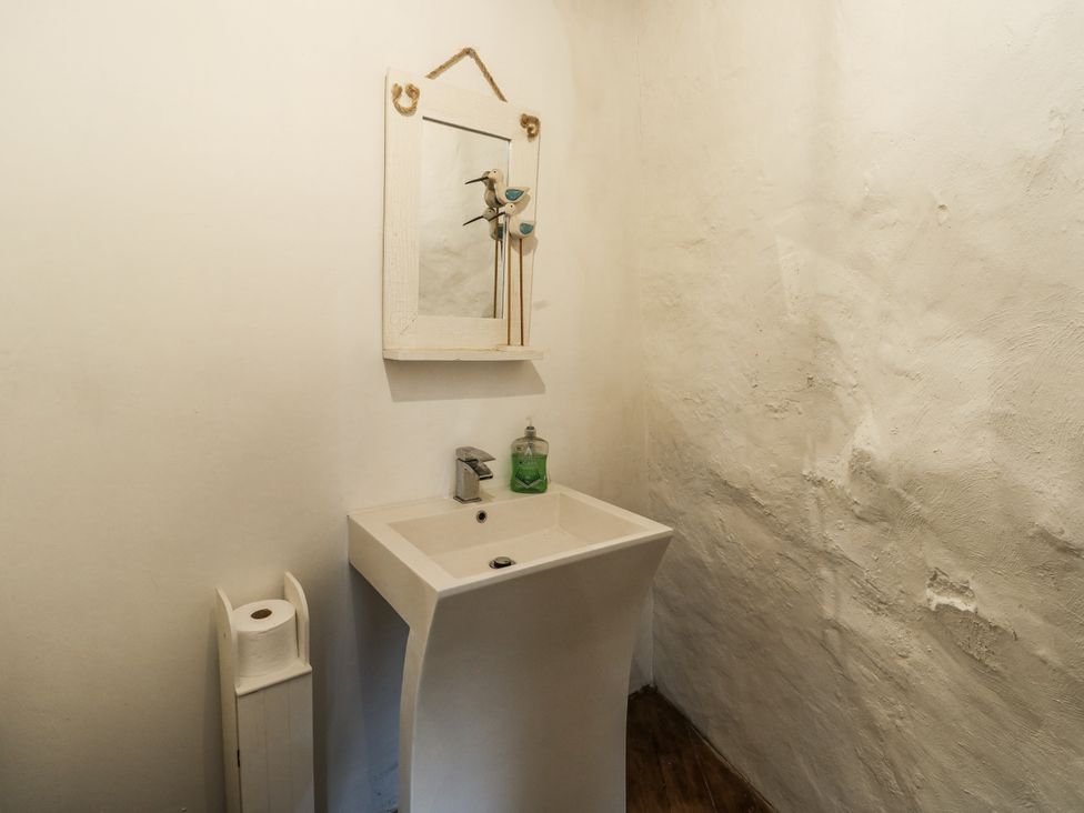 A bathroom with a washbasin and mirror at The Old Cornmill in Cemaes Bay