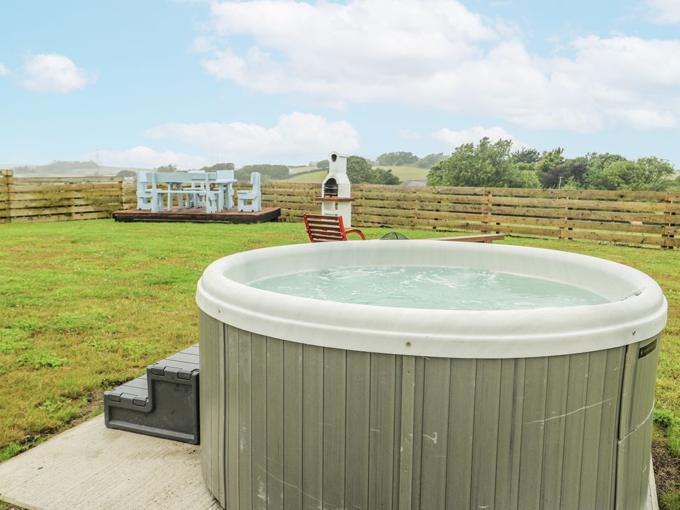 A hot tub and outdoor furniture in a garden at The Old Cornmill in Cemaes Bay