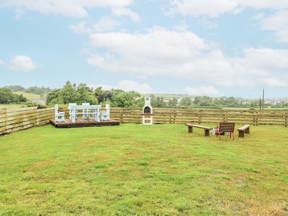 A garden with seating and a grill at The Old Cornmill in Cemaes Bay