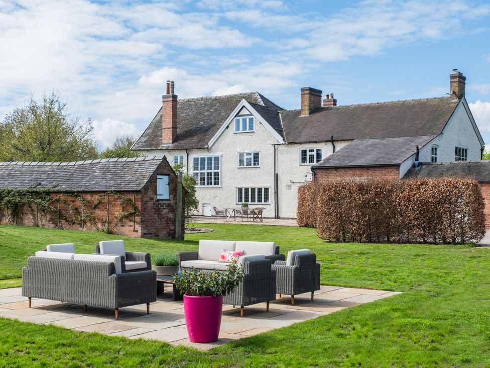 A garden with patio furniture and a house at Hall O'Coole in Broomhall near Wrenbury