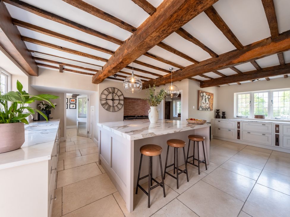 A kitchen with a central island and stools at Hall O'Coole in Broomhall nearn Wrenbury