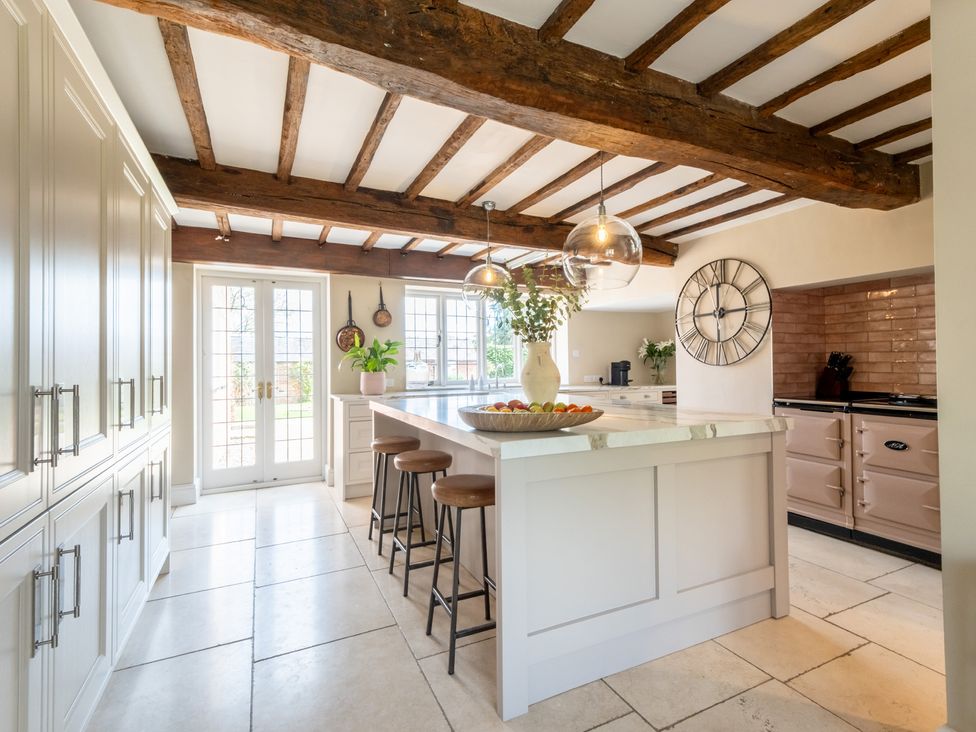 A kitchen with an island and bar stools at Hall O'Coole in Broomhall nearn Wrenbury