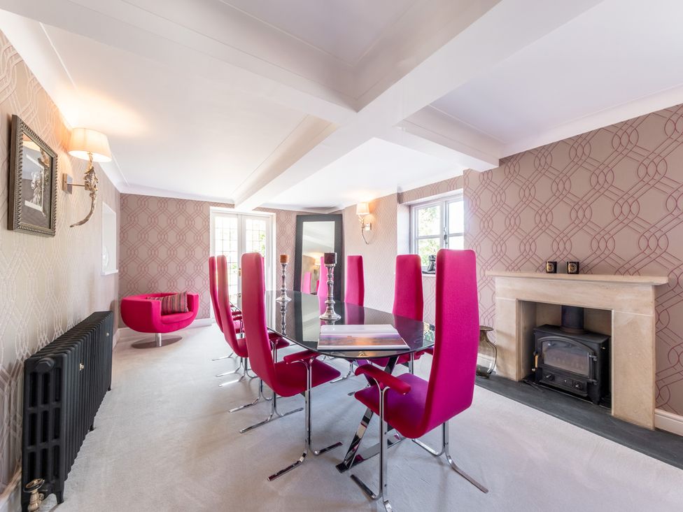 A dining room with a table and pink chairs at Hall O'Coole in Broomhall nearn Wrenbury