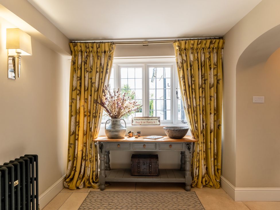 A hallway with a table and flower arrangement at Hall O'Coole in Broomhall nearn Wrenbury
