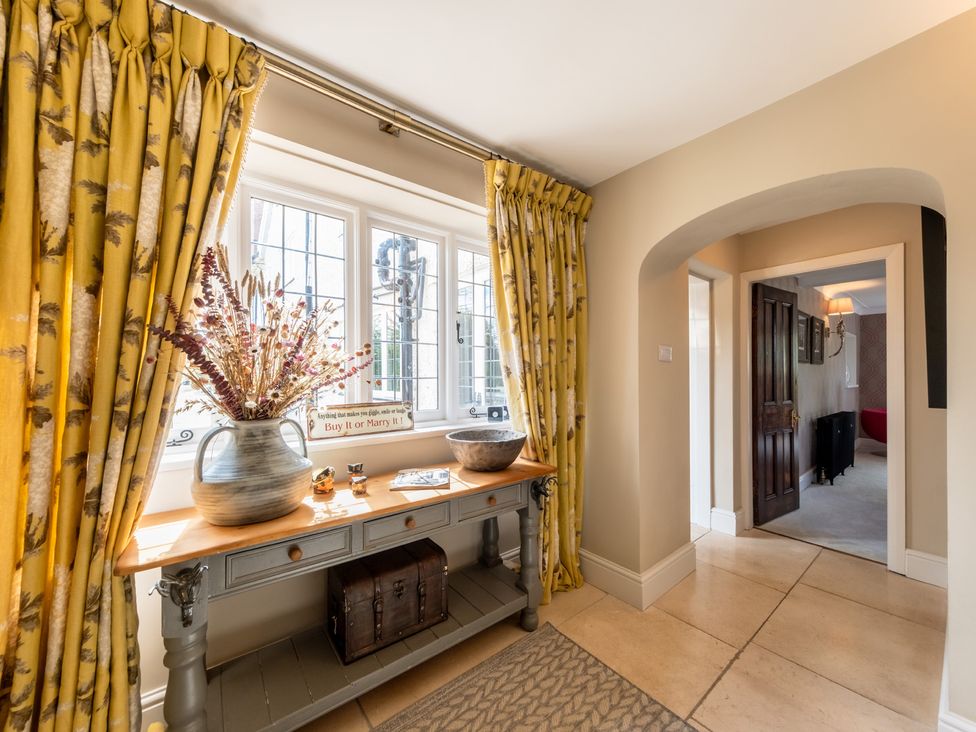 A hallway with a console table and decorative items at Hall O'Coole in Broomhall near Wrenbury