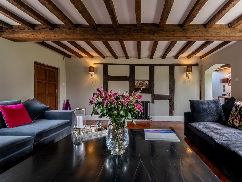 A living room with a vase of flowers on a coffee table at Hall O'Coole in Broomhall nearn Wrenbury