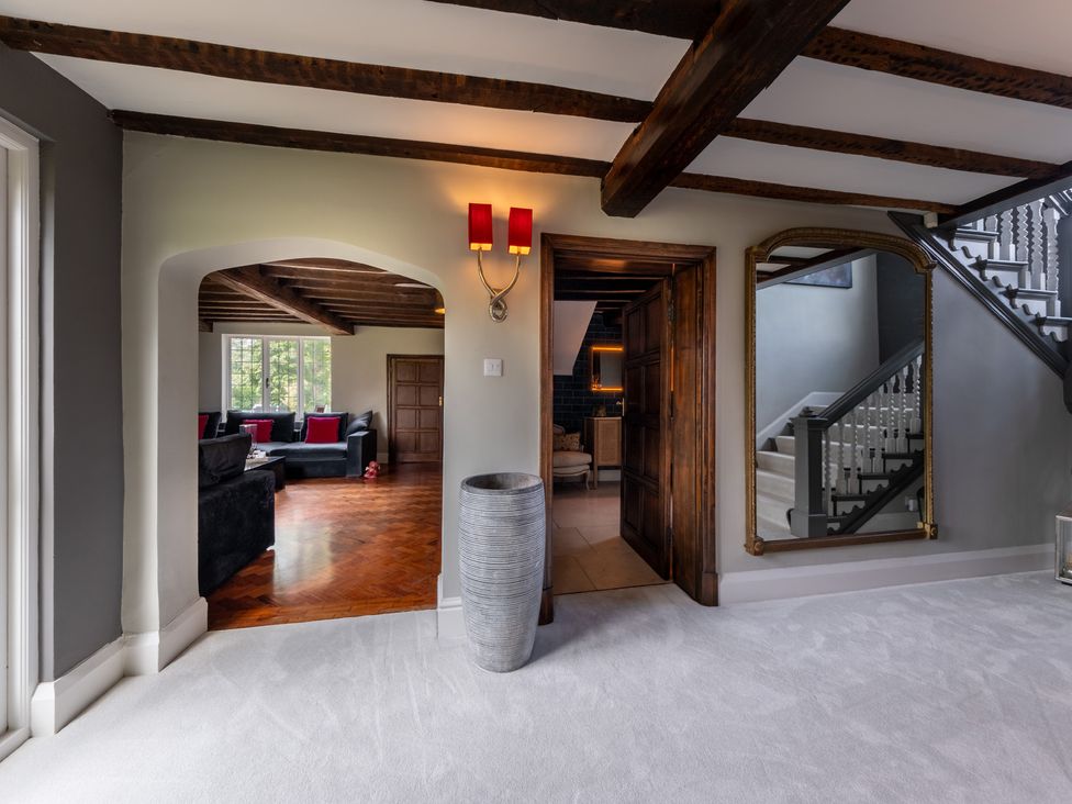 A hallway with a staircase and a mirror at Hall O'Coole in Broomhall nearn Wrenbury