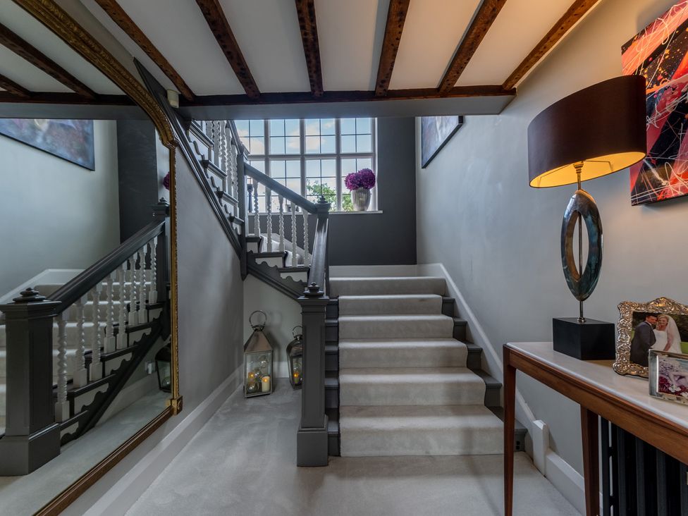 A hallway with stairs and a lamp at Hall O'Coole in Broomhall nearn Wrenbury