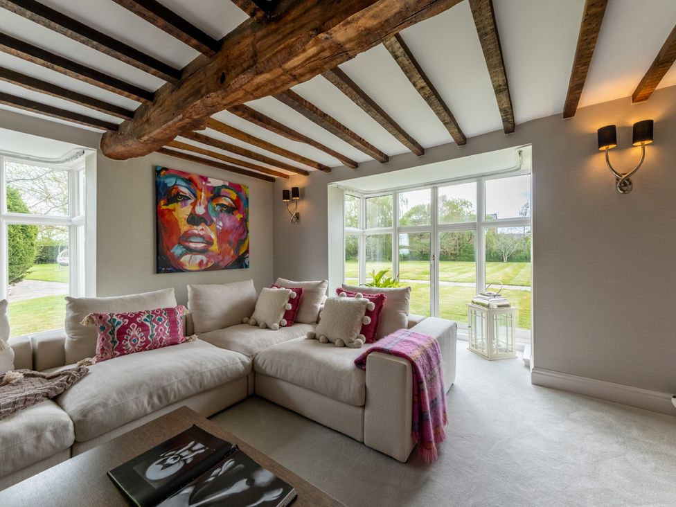 A living room with a sofa, cushions, and artwork at Hall O'Coole in Broomhall nearn Wrenbury