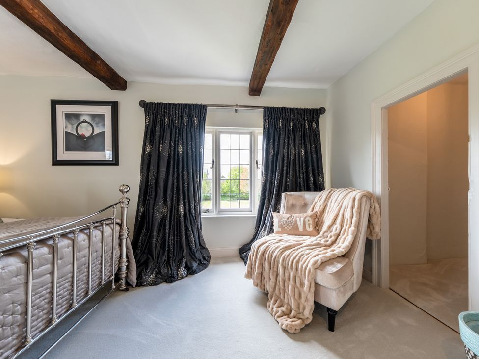 A bedroom with a bed and armchair at Hall O'Coole in Broomhall nearn Wrenbury