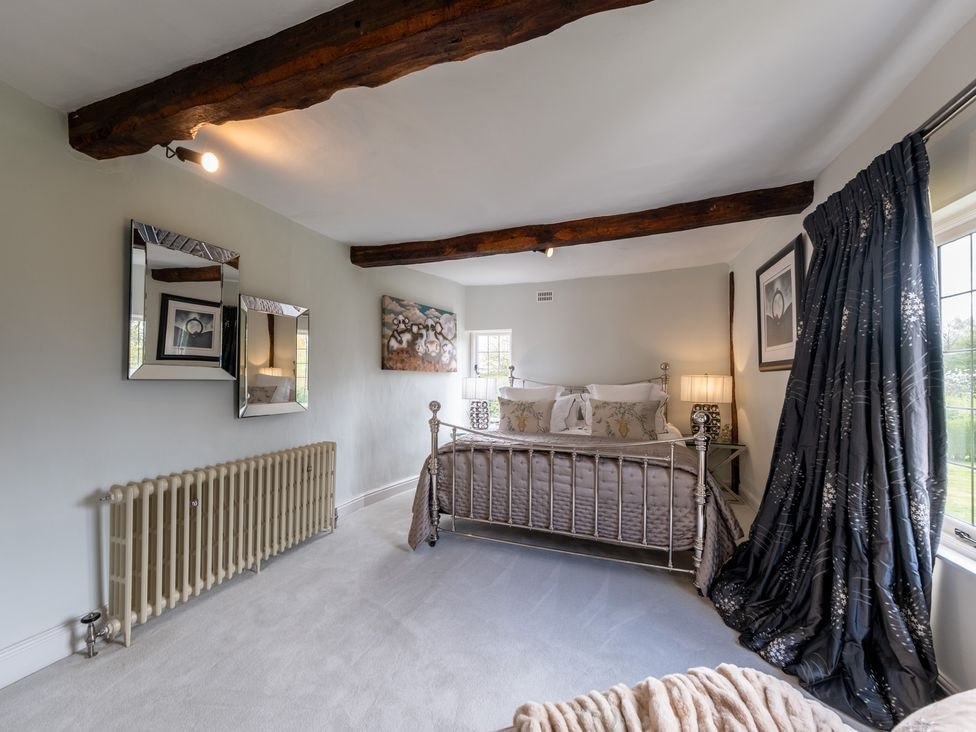 A bedroom with a bed and mirrors at Hall O'Coole in Broomhall near Wrenbury