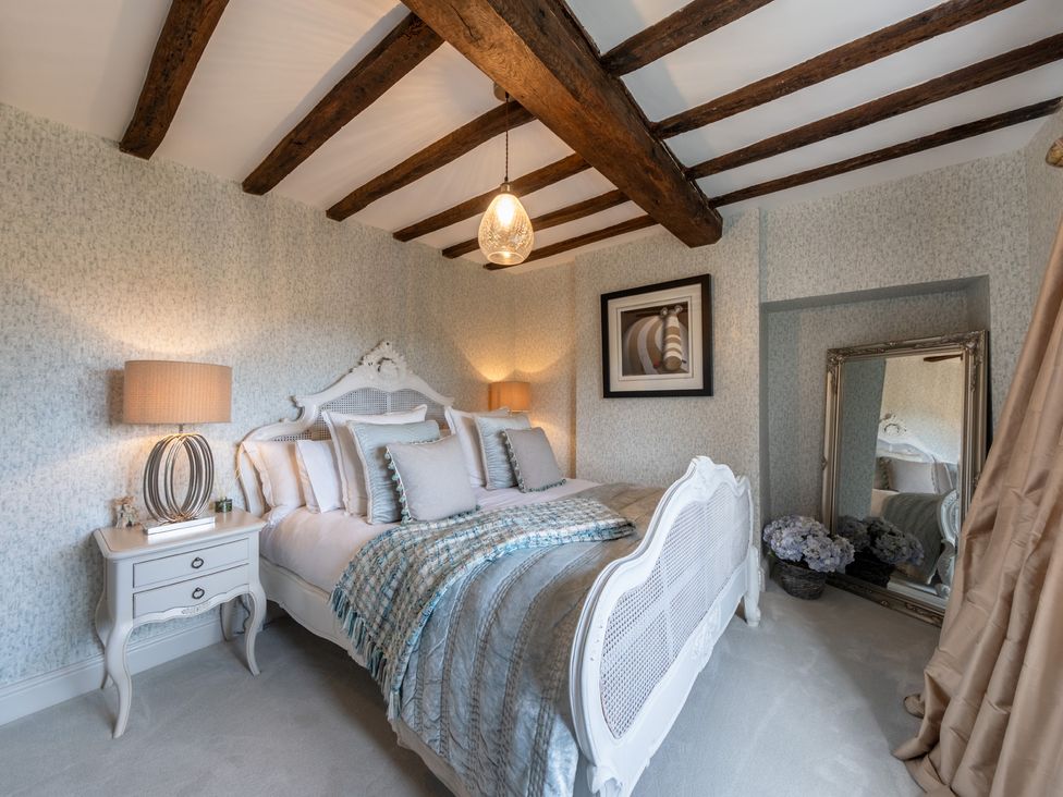 A bedroom with a bed and mirror at Hall O'Coole in Broomhall near Wrenbury
